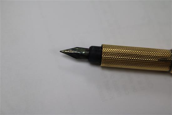 An Edwardian engine turned yellow metal fountain pen, with engraved inscription, 12.6cm.